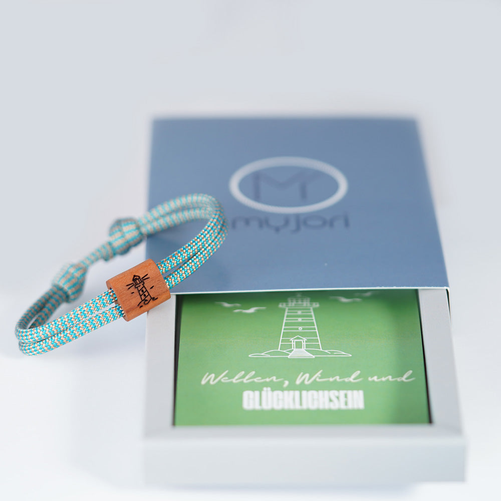 Verstellbares Outdoor-Armband aus türkisfarbenen Segeltau mit Holzschieber und Leuchtturm-Gravur in hochwertiger Schiebeschachtel.