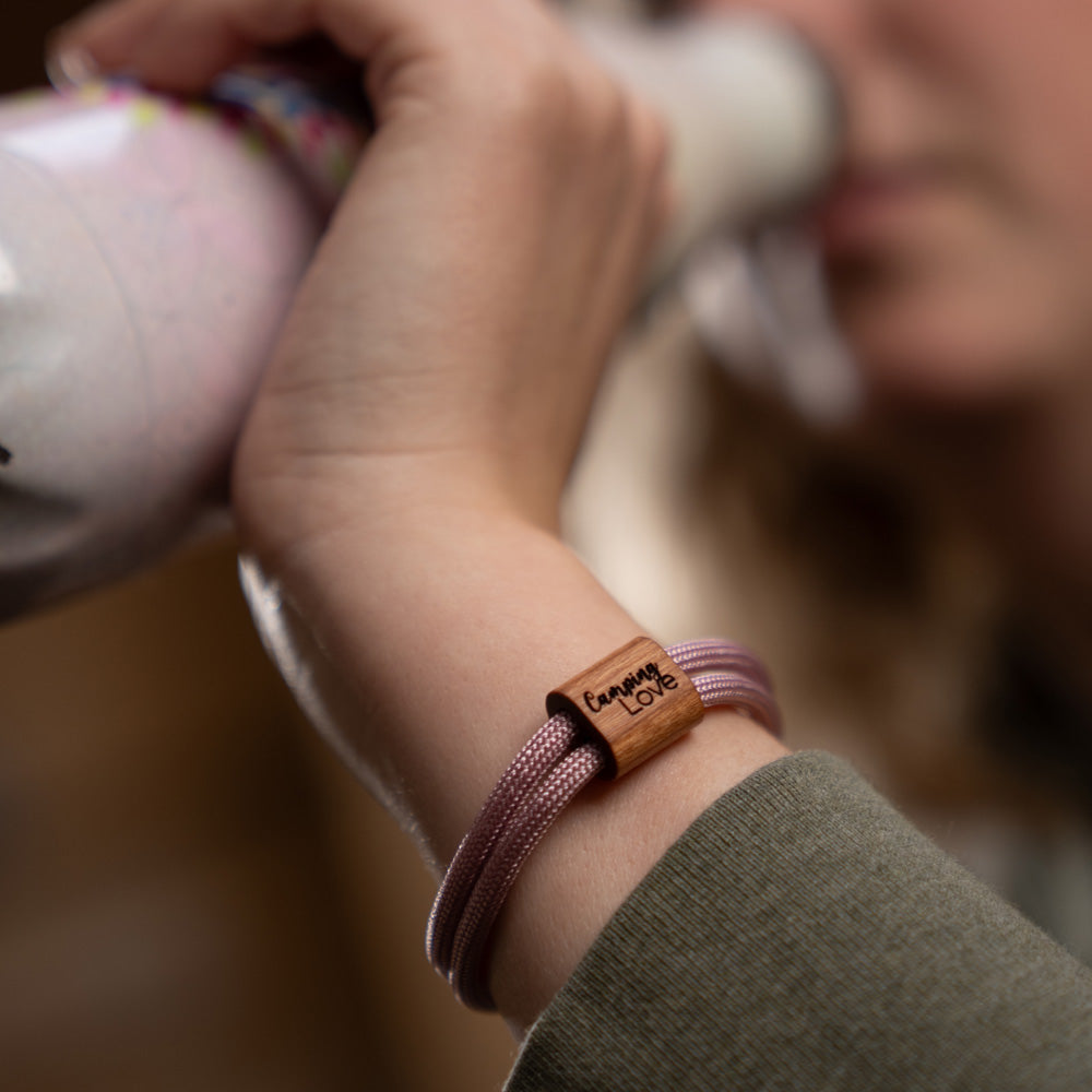 Verstellbares Outdoor-Armband aus rosafarbenen Segeltau mit Holzschieber und Camping Love-Gravur (Schriftzug) mit Schiebeverpackung.
