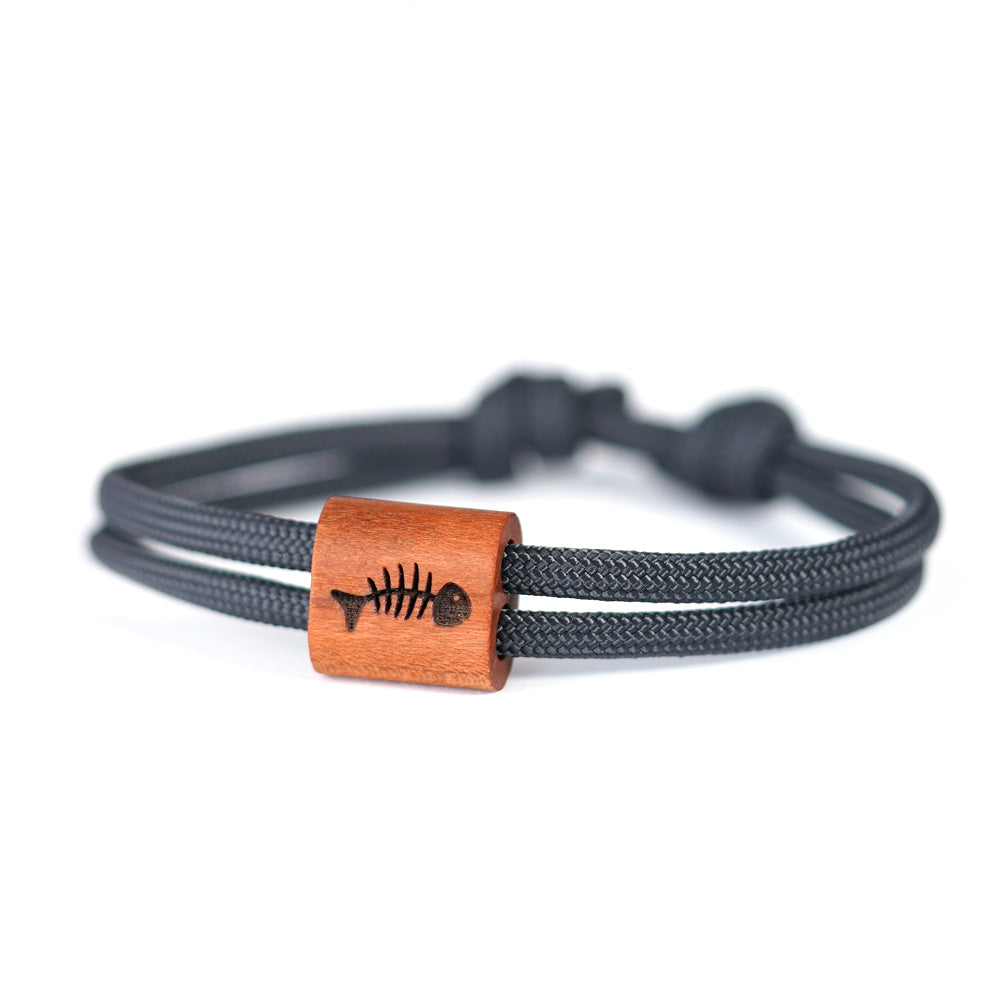 Verstellbares Outdoor-Armband aus anthrazitfarbenen Segeltau mit Holzschieber und Fischgräte-Gravur in hochwertiger Schiebeschachtel.